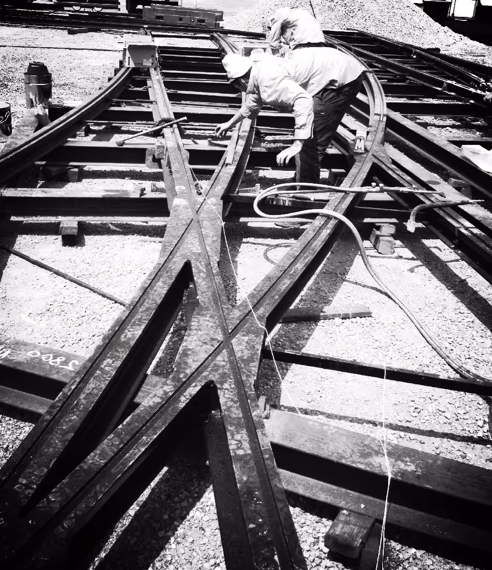 Two Fast Track Welding crew working a rail crossing with welding leads run out.