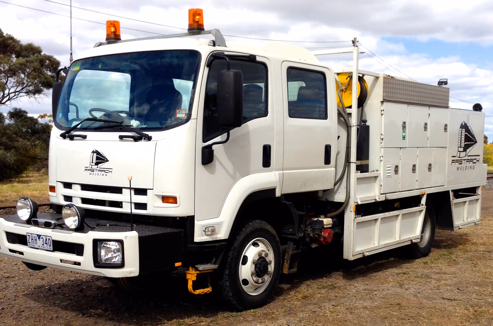 A Fast Track Welding hi-rail truck parked beside the track.