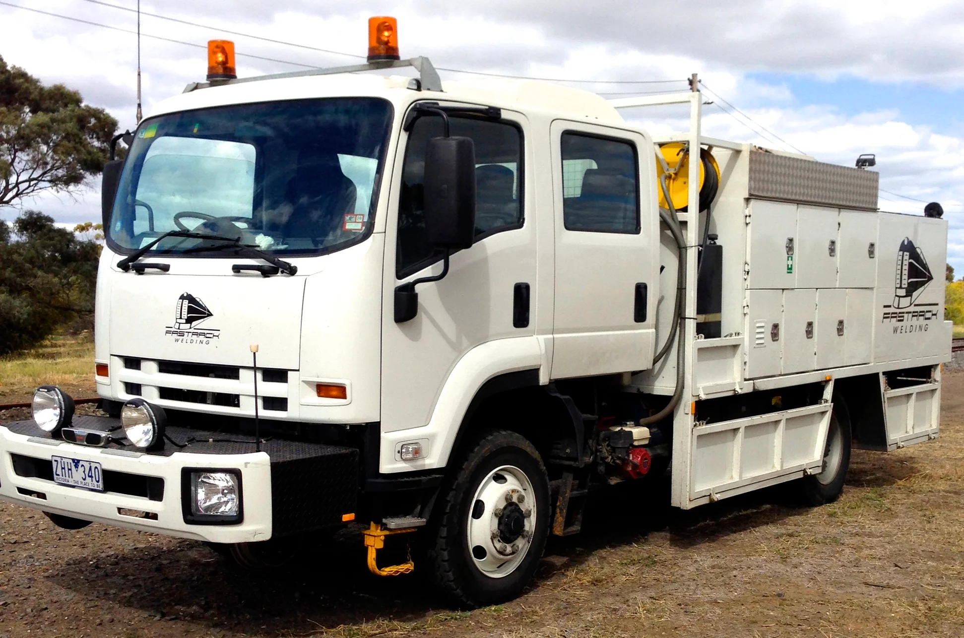 A Fast Track Welding hi-rail truck parked beside the track.